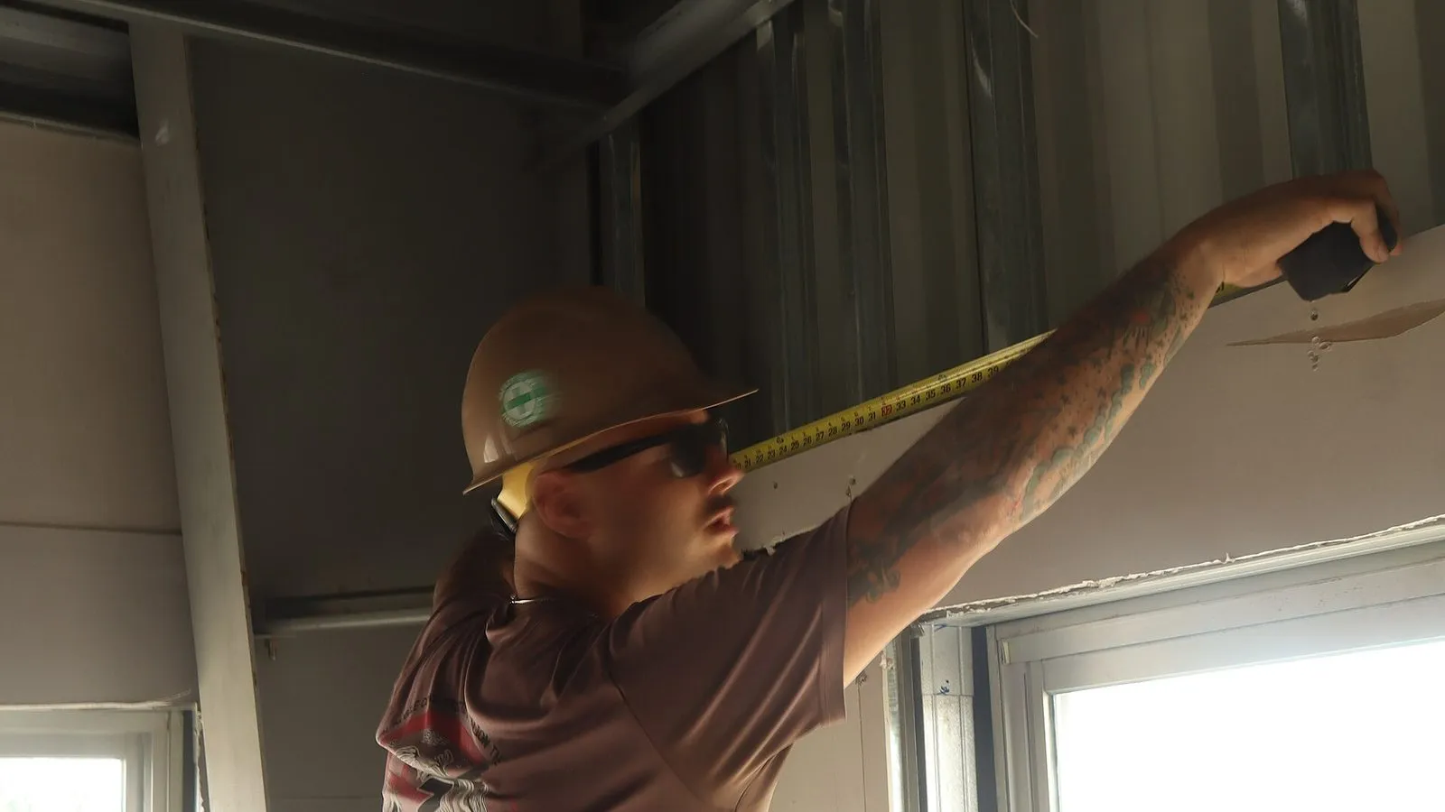 Worker hanging drywall sheets during installation