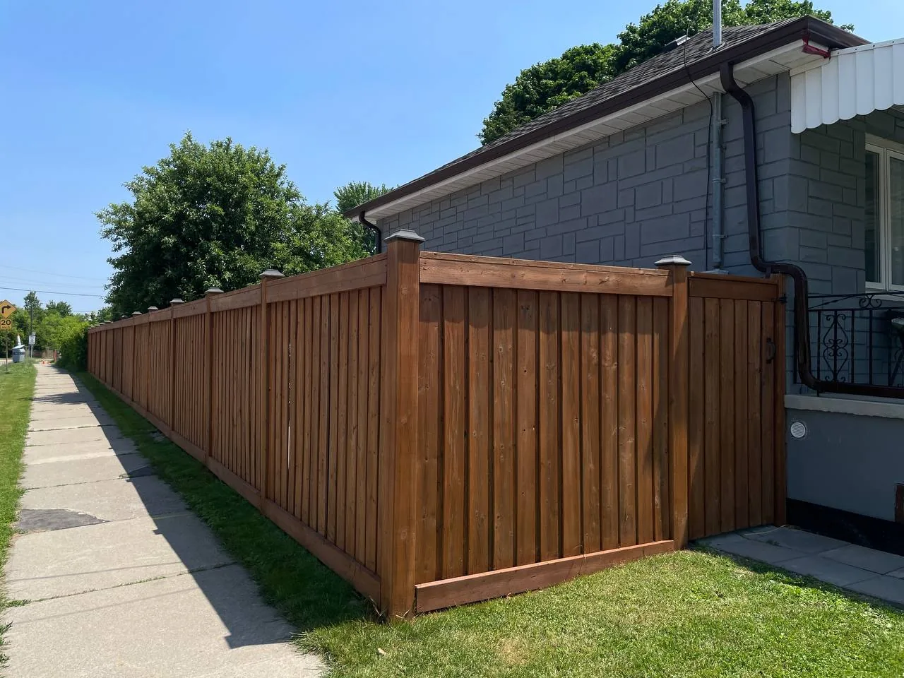 Exterior wood staining beside a bungalow in North York by Co Painting